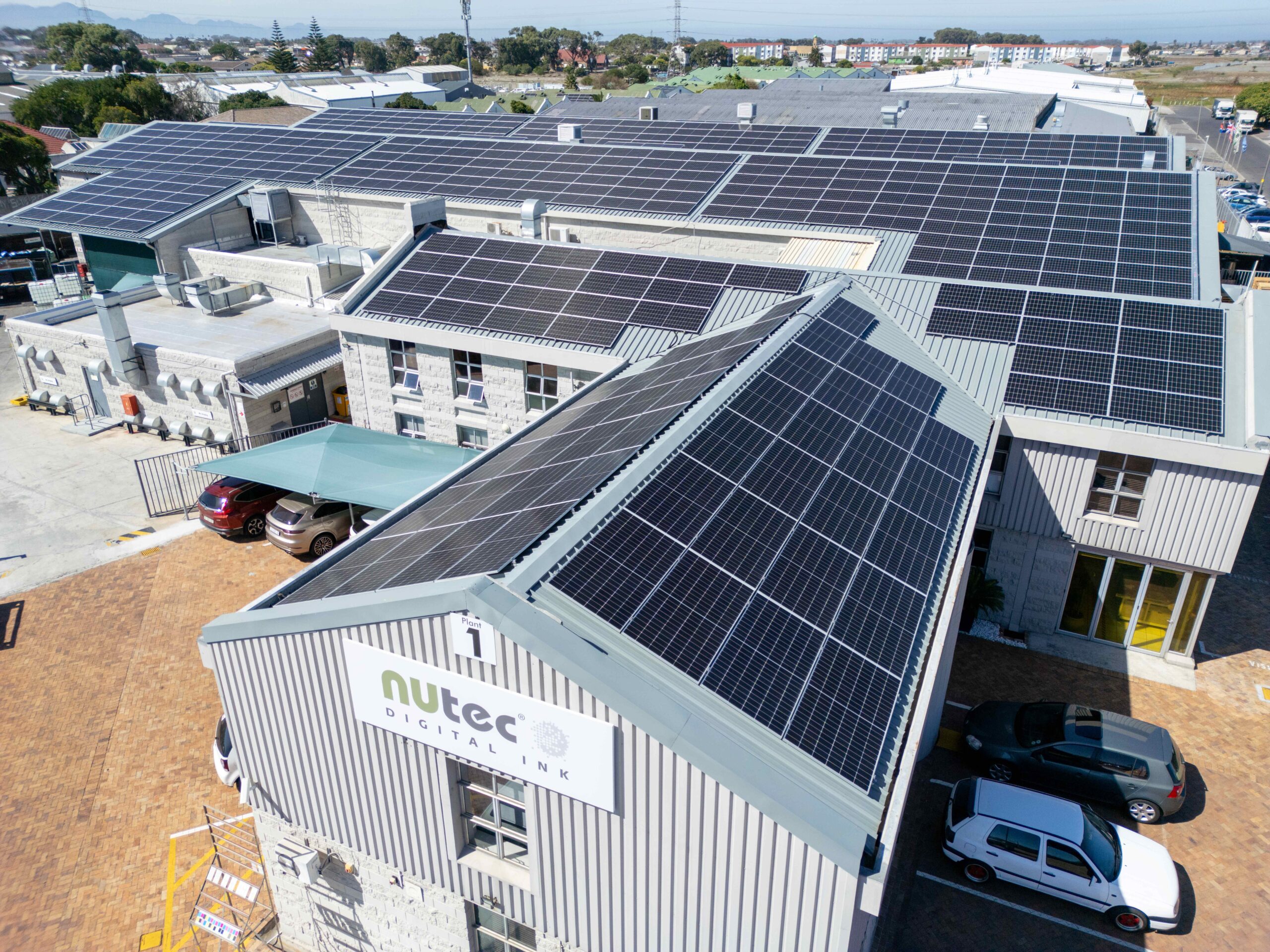Roof with multiple solar panels installed on NUtec Digital Ink's facility for clean energy production, demonstrating sustainable digital printing solutions.