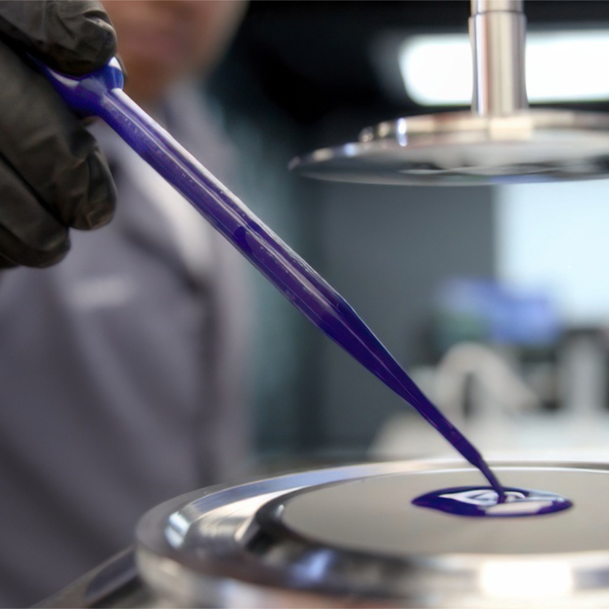 Close-up of NUtec Digital Ink's printing ink being poured onto a digital printer surface, showcasing ink technology for digital printing applications